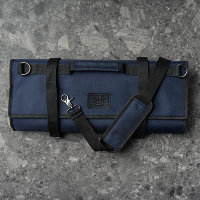 Closed ITAMAE navy ballistic knife bag with black straps and shoulder sling, designed for chefs and culinary professionals