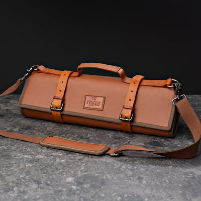 ITAMAE Nara Knifebag in tan leather, rolled and secured with straps, featuring shoulder strap and handle for chefs to carry knives and tools.
