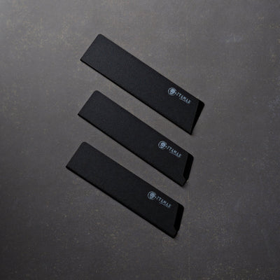 Three black itamae knife guards on a dark gray surface